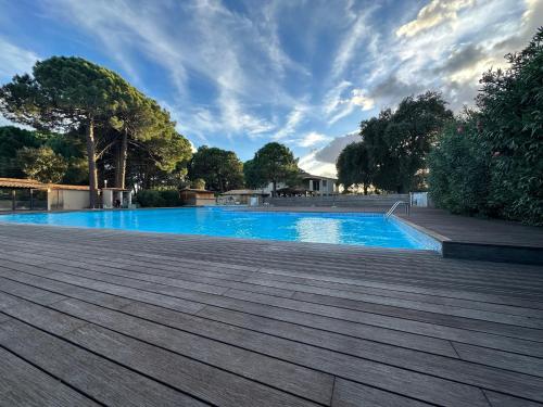 LecciT4 neuf Porto Vecchio Calarossa的一个带木制甲板的蓝色游泳池