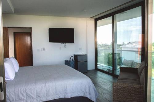 奥尔沃克斯岛Casa de tus Sueños的一间卧室配有一张床、一张沙发和一台电视