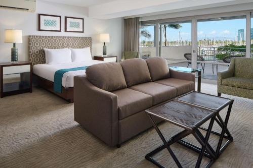 檀香山伊利凯豪华公寓式酒店的酒店客房,配有床和沙发