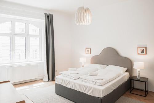 维也纳HeyMi Apartments Zentagasse的白色的卧室设有一张大床和一个窗户
