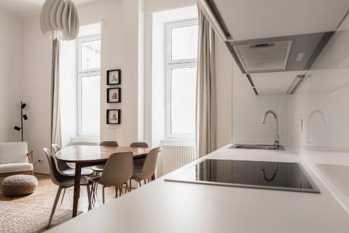 维也纳HeyMi Apartments Zentagasse的厨房以及带桌椅的用餐室。