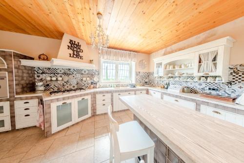 Prata di Principato UltraVilla Le Cicale - Irpinia的厨房配有白色橱柜和木制天花板
