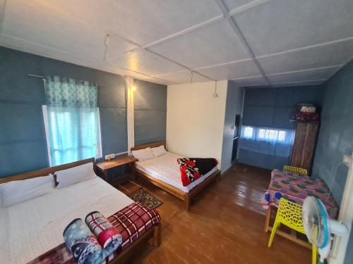 BokākhātSparrow Nest Cottages的一间卧室配有两张床、一张沙发和一把椅子