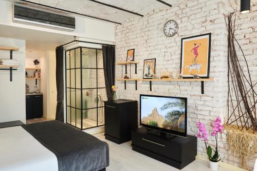 伊斯坦布尔Magnova Studios的一间带电视和砖墙的卧室