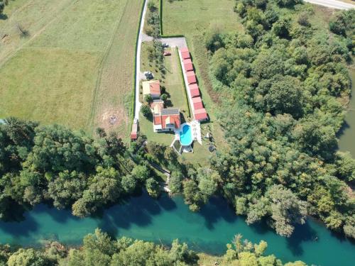DanilovgradSeosko domaćinstvo Jovanović的享有农场的空中景色,设有房屋和湖泊