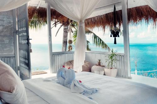 珀尼达岛Tropical Glamping Nusa Penida - Private Romantic Seaside Bungalow Diamond Beach的一间卧室设有一张床,享有海景
