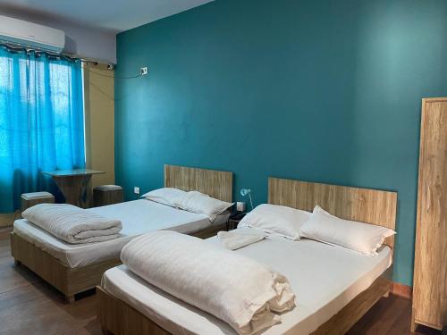 AtariaNamaste Hotel的蓝色墙壁客房的两张床