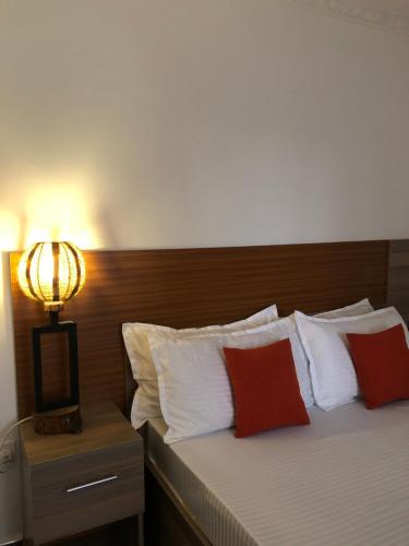 KakamegaSavwa Resort and Gardens的一间卧室配有红色和白色枕头的床