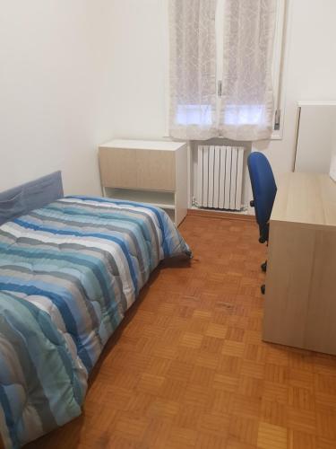 伊莫拉Casa frà i Pini的一间卧室配有一张床、一张桌子和一把椅子
