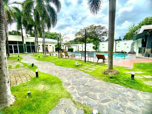 安吉利斯Hotel Euroasia By BLUEBOOKERS的一个带游泳池和棕榈树的度假庭院