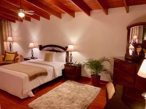 利马Casa Bella Boutique Hotel San Isidro的一间卧室配有一张床、一把椅子和一张桌子