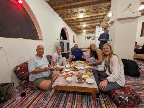 锡瓦Cafour House Siwa - Hot Spring的一群坐在桌子旁吃饭的人