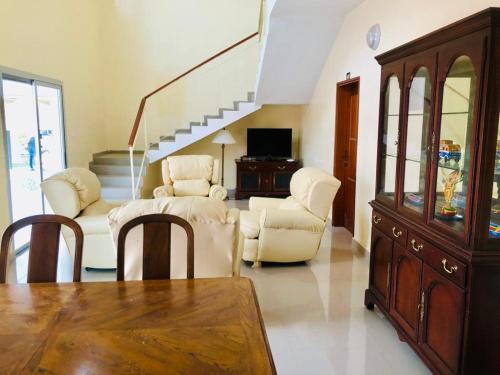 尼亚加托尔比酒店的客厅配有白色家具和楼梯
