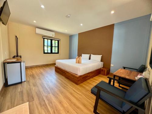 达叻府Napdown Resort Trat นับดาว รีสอร์ท ตราด的卧室配有1张床、1张桌子和1把椅子