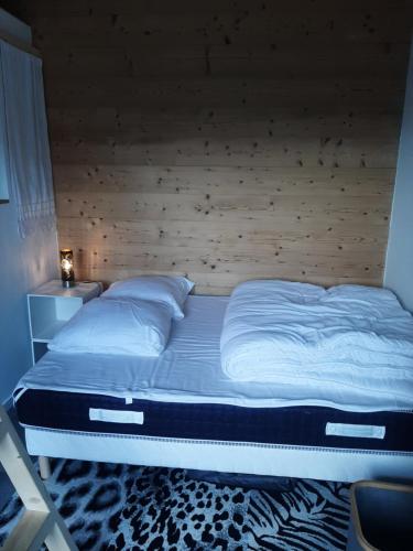 Viuz-en-Sallaz5 min des pistes de ski Grand studio mezzanine的卧室内的一张带木制床头板的大床