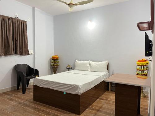KharakvaslaLotus Guest House的一间卧室配有一张床和一把椅子
