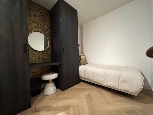 于尔克Bij de Haven op Urk的一间卧室配有床、镜子和凳子