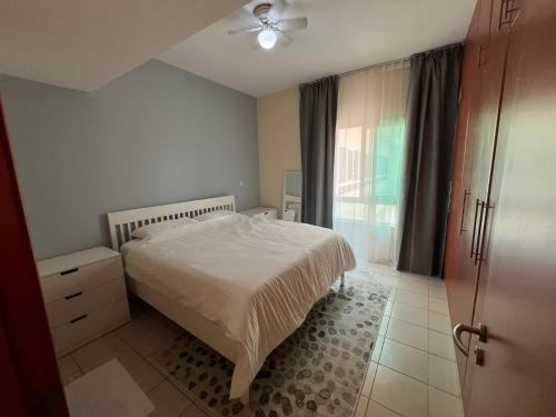 迪拜Nice Location - 76 m2的卧室配有白色的床和窗户。