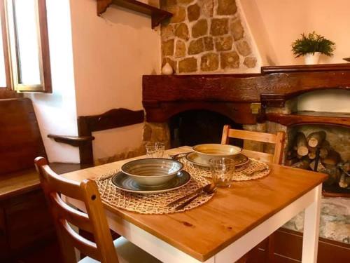 罗卡迪梅佐Baita delle Rocche的壁炉上木桌,上面放有盘子和碗