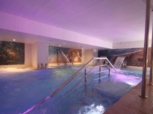 卡萨布兰卡New Hotel Piscine Wellness & Spa的画作的大房间中的游泳池
