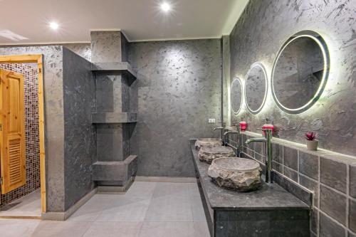赫尔格达Bedcoin Hostel的浴室设有石质水槽和两面镜子。