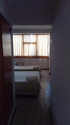 维拉卡洛斯帕兹HOTEL CRONOS的一间卧室设有两张床和窗户。