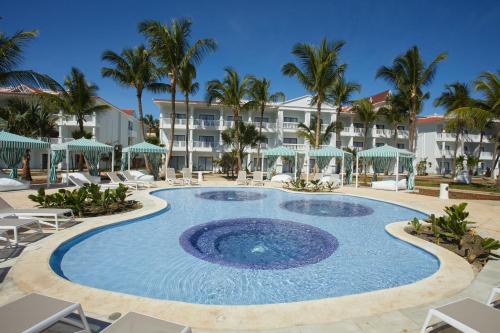 蓬塔卡纳Bahia Principe Luxury Esmeralda All Inclusive - Newly Renovated的度假酒店的游泳池配有椅子和遮阳伞