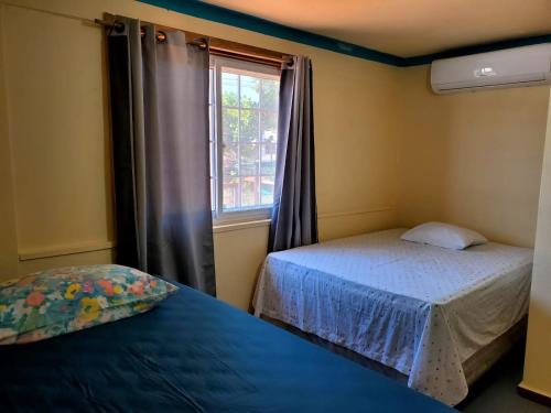 西区Hotel Caribbean Inn的一间小卧室,配有两张床和窗户