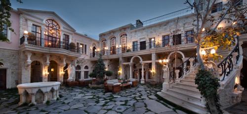 于尔居普萨科里德之家酒店的一座带石头庭院的大型建筑,设有楼梯