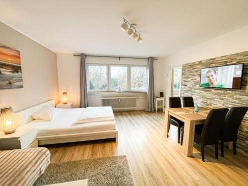 不莱梅Business Apartment Altstadt的一间卧室配有一张床、一张桌子和一台电视。