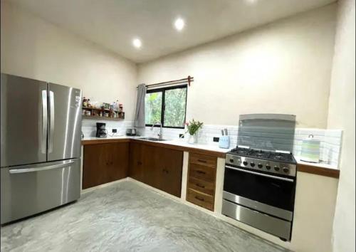 艾库玛尔Keiki House的厨房配有炉灶和冰箱。