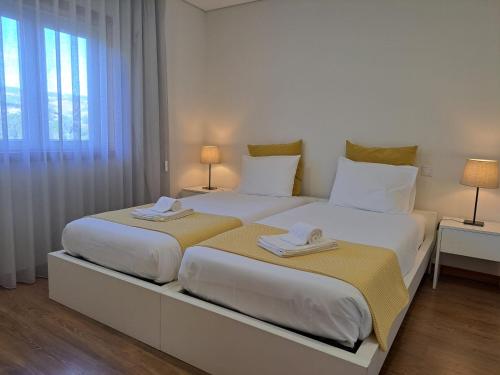 比索达雷加Quinta da Portelada的卧室内两张并排的床
