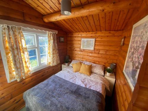 特兹西尼德Cosy Log Cabin Snowdonia Eryri的小木屋内一间卧室,配有一张床
