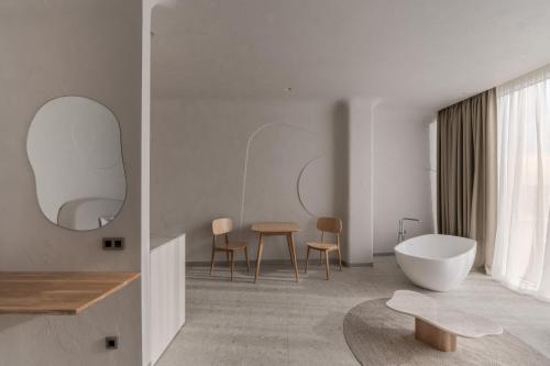 敖德萨Sfumato Rooms的白色的浴室设有浴缸和桌子。