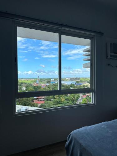 巴科洛德Cozy Condo bedroom in Bacolod City的卧室内的窗户享有城市美景