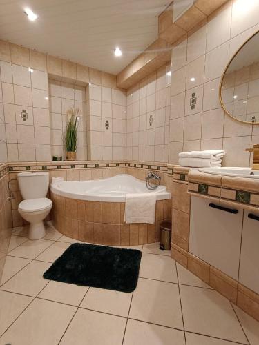 塞伊内Apartament Wileńska 15的带浴缸、卫生间和盥洗盆的浴室