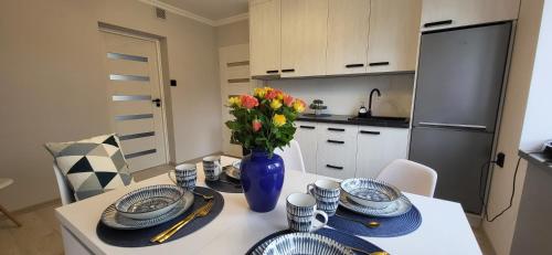 塞伊内Apartament Wileńska 15的厨房配有带盘子和花瓶的桌子