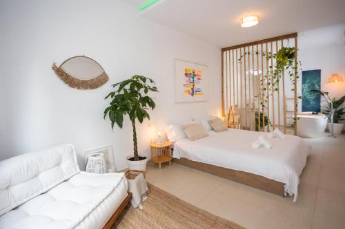 卡拉德莫尔Naim Playa的一间卧室配有床、沙发和植物