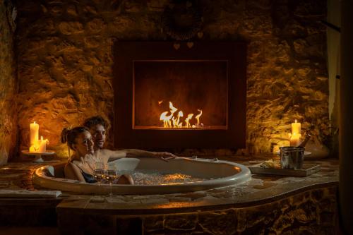 圣奎里科-多尔恰PALAZZO DEL CAPITANO Wellness & Relais - Luxury Borgo Capitano Collection的坐在壁炉前浴缸中的女人