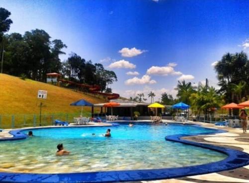 菲格雷多总统镇ECO CHALÉ PARK CACHOEIRAS的和水中的人在度假村的游泳池