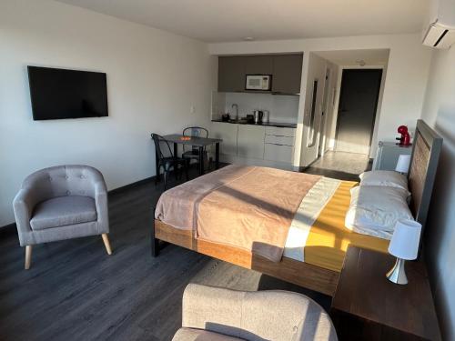 蒙得维的亚EUGE Apart的一间卧室配有一张床和一把椅子,一间厨房