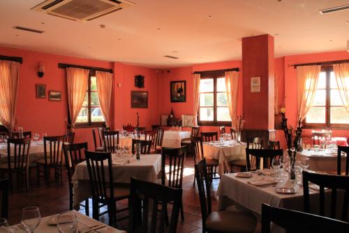 加尔甘塔劳利亚卡洛斯一世乡村酒店的一间设有桌椅和红色墙壁的餐厅