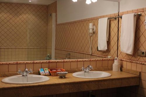 加尔甘塔劳利亚卡洛斯一世乡村酒店的一间带两个盥洗盆和大镜子的浴室