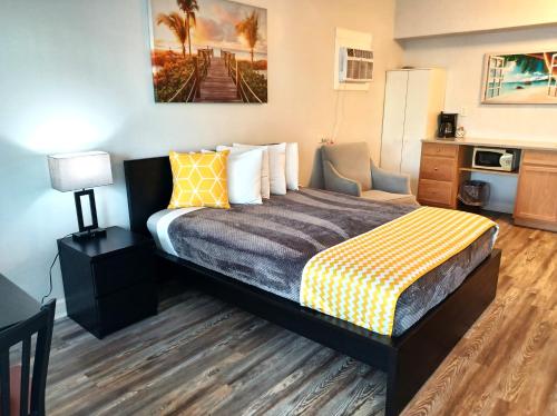 圣徒皮特海滩约翰斯通海滩汽车旅馆 的酒店客房的床铺配有黄色和灰色的毯子