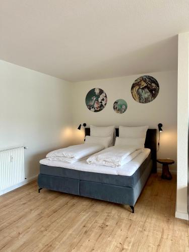 巴特萨克萨Ferienwohnung Bad Sachsa Harz II的卧室配有一张床和墙上的2个盘子