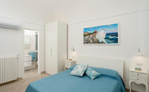 阿纳卡普里Caprita Guest House的卧室配有蓝色的床和墙上的绘画作品