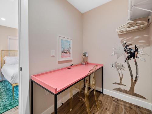 圣地亚哥Classic Beach Bungalow - Parking, Private Patio & Pet Friendly!的一张粉红色的书桌,位于带床的房间