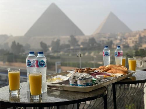 开罗Unique Pyramids View INN的一张桌子,上面放着食品和橙汁