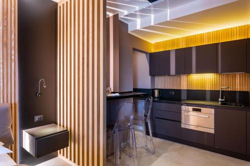 多索博诺La Pergola Suites的厨房配有黑色橱柜、水槽和椅子