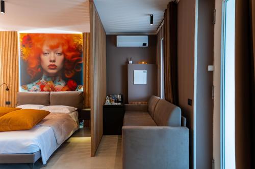 多索博诺La Pergola Suites的卧室配有一张床,墙上挂有绘画作品